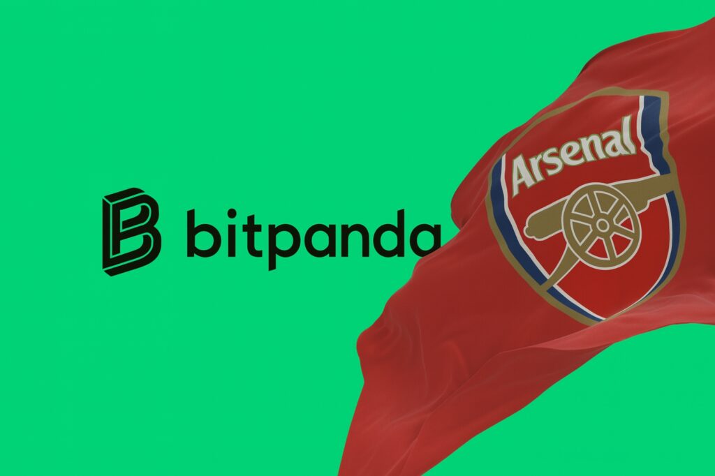Bandera del Arsenal ondeando junto al logo de Bitpanda sobre fondo verde, representando la alianza de patrocinio deportivo y expansión fintech en Reino Unido.