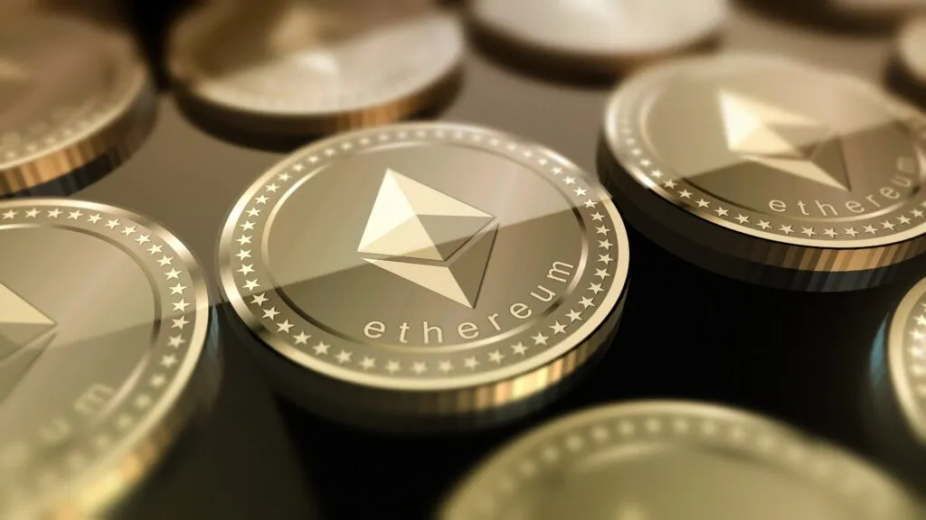 Primer plano de monedas físicas de Ether con el logotipo de Ethereum, representando el crecimiento de Ether frente a Bitcoin en los mercados.
