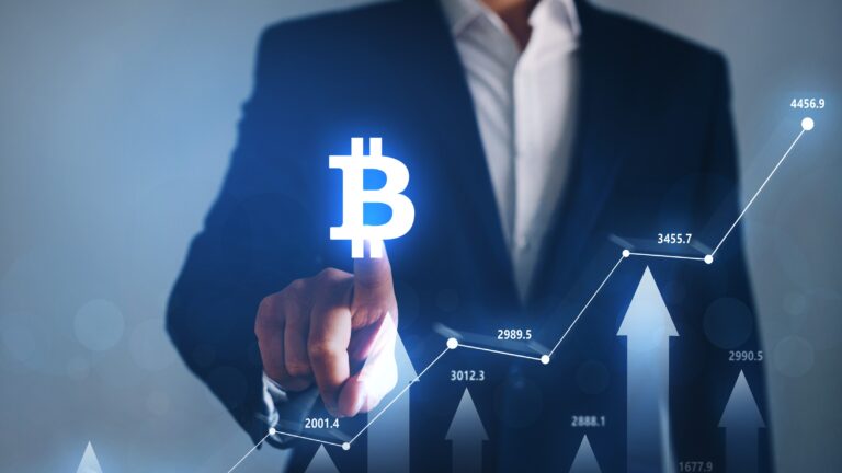 Hombre de negocios tocando el símbolo de Bitcoin con gráfico ascendente, reflejando el alza a más de 64 mil dólares tras señales de la Fed sobre posibles recortes de tasas.