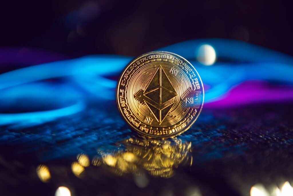 Moneda física de Ethereum sobre una superficie oscura iluminada por luces azul y púrpura, simbolizando impulso del mercado y confianza en el precio de ETH.