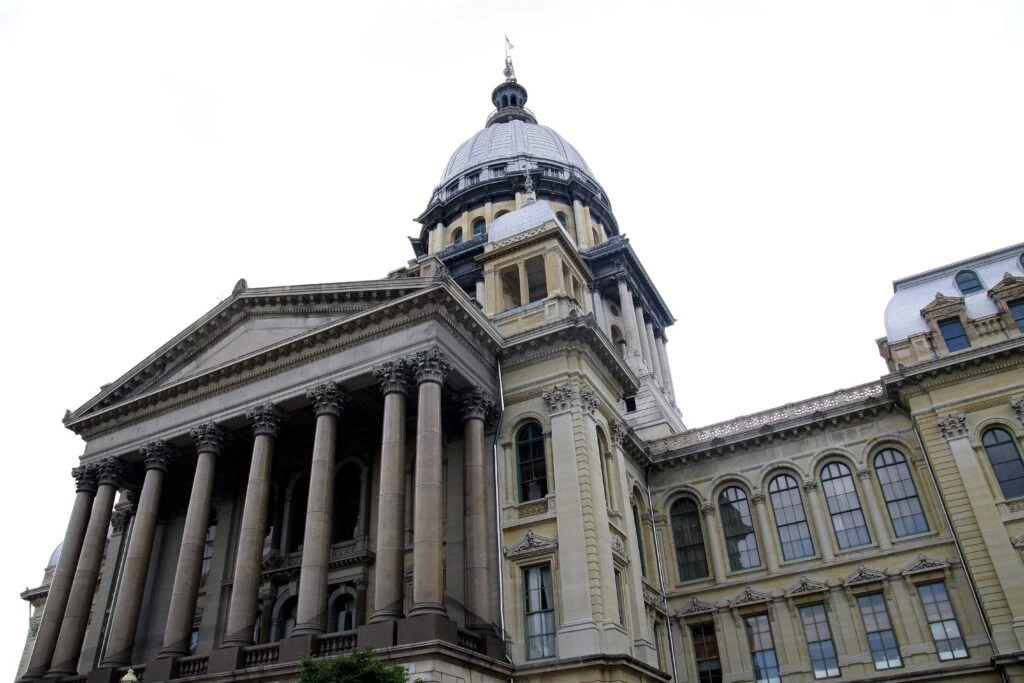 Monedas digitales y documentos fiscales que representan el conflicto legal por el impuesto a las criptomonedas en Illinois.