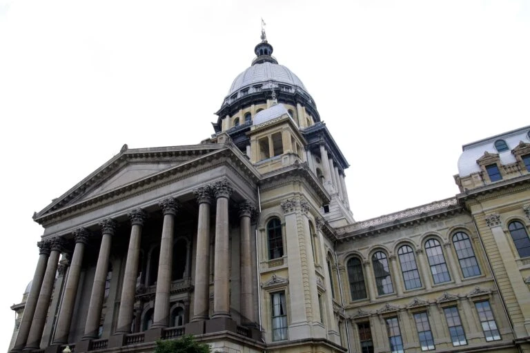 Monedas digitales y documentos fiscales que representan el conflicto legal por el impuesto a las criptomonedas en Illinois.