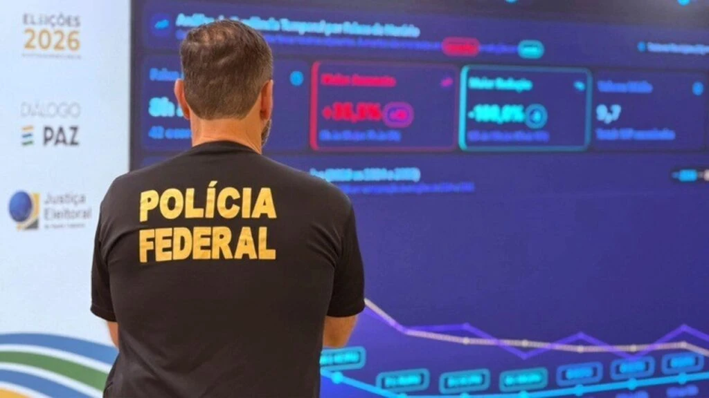 Monedas digitales doradas junto a una bandera de Brasil y una computadora con gráficos financieros, representando el uso de criptomonedas en publicaciones electorales.